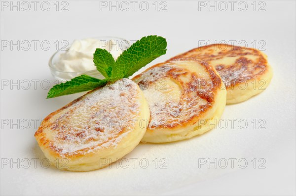 Cottage cheese fritters with sugar powder on a plate