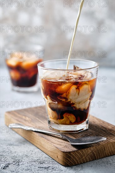 Pouring cream in iced coffee