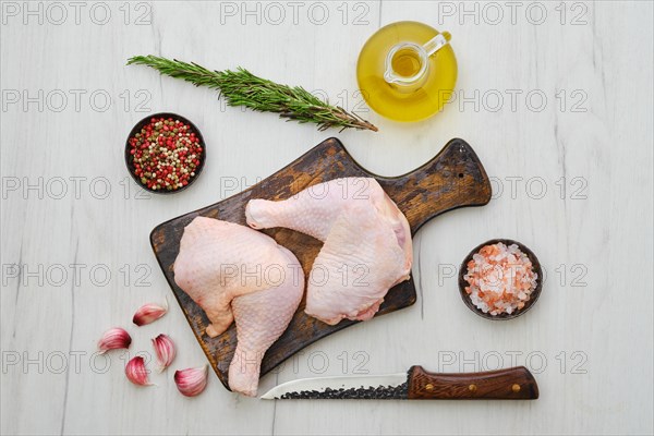 Overhead view of raw chicken thighs on wooden cutting board ready for cooking
