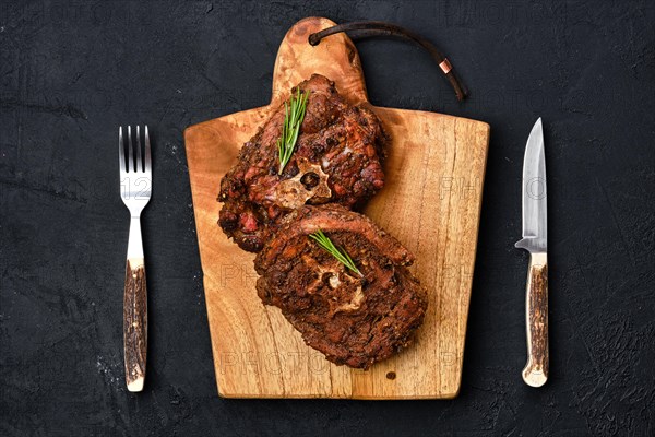 Top view of grilled lamb neck on wooden cutting board