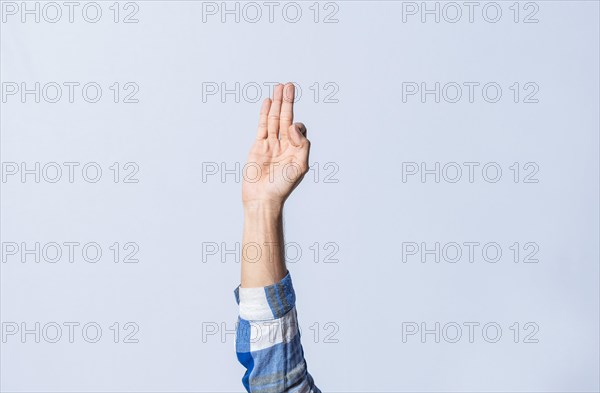 Hand gesturing the letter F in sign language on isolated background. Man hand gesturing the letter F of the alphabet isolated. Letters of the alphabet in sign language