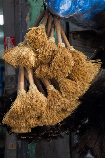 Set of yellow straw broom in a bazaar