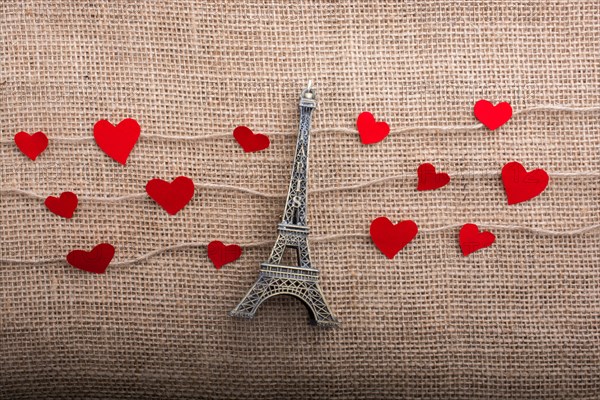 Love concept with Eiffel tower and paper heart on threads