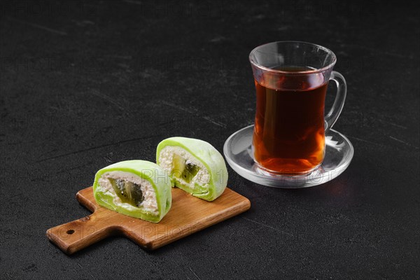 Sweet dessert mochi with kiwi cut on half and fruit tea