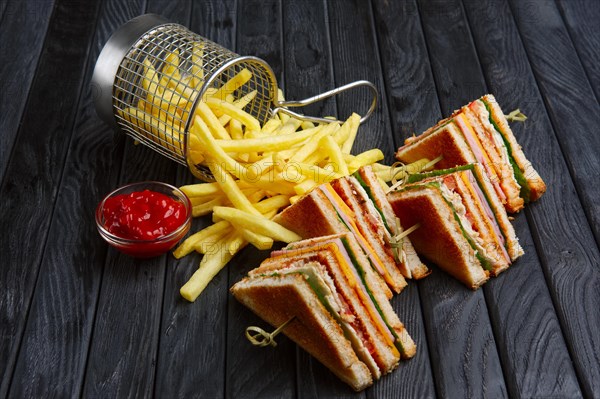 Club-sandwich with french fries in metal basket