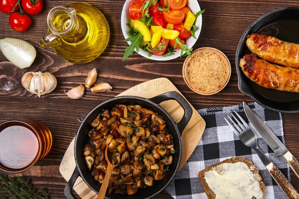 Fried mushrooms and sausage in cas-iron skillet. Ingredients for rustic simple food