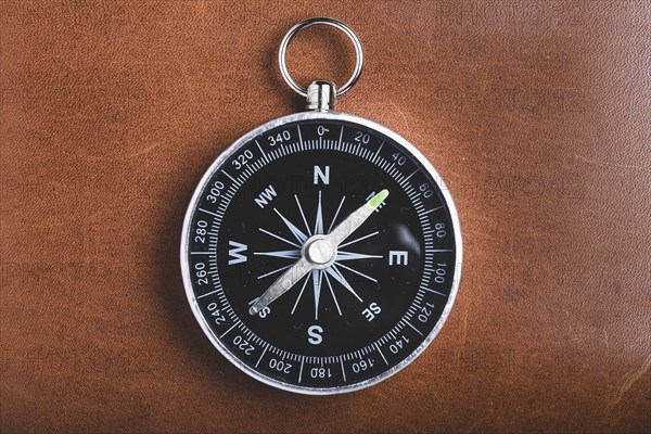 Close up of compass on wooden background