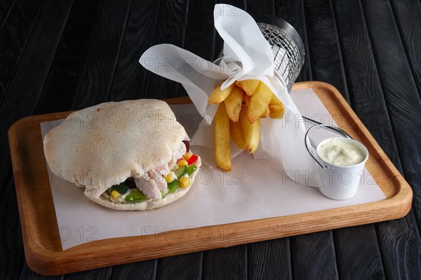 Pita bread with chicken and vegetables served with fried potato