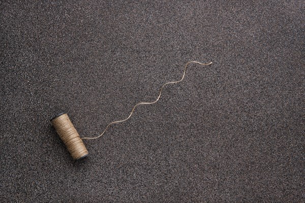 Top view of untwisted linen twine on dark stone background
