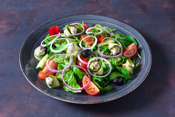 Fresh salad with zucchini stuffed with feta cheese with tomato