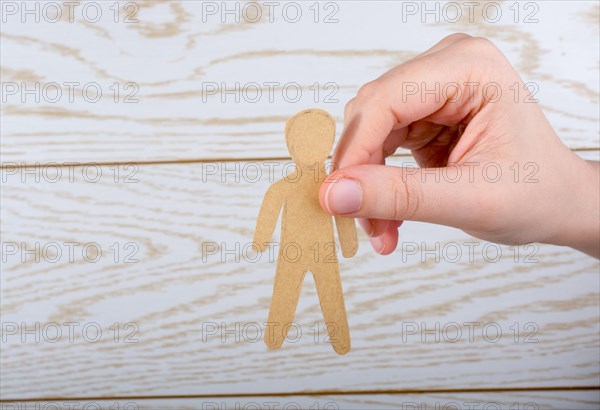 Man shape cut out of paper in hand in the view
