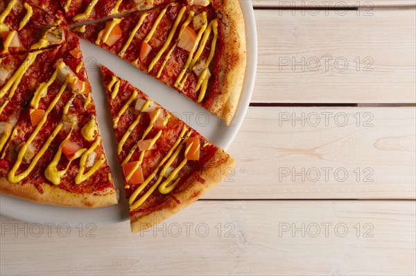 Top view of pizza with sun-dried tomatoes and mustard sauce