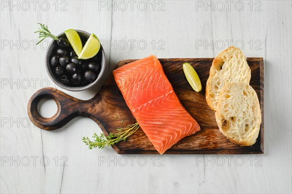 Top view of piece of fresh salmon steak with ciabatta and spicy herb sauce