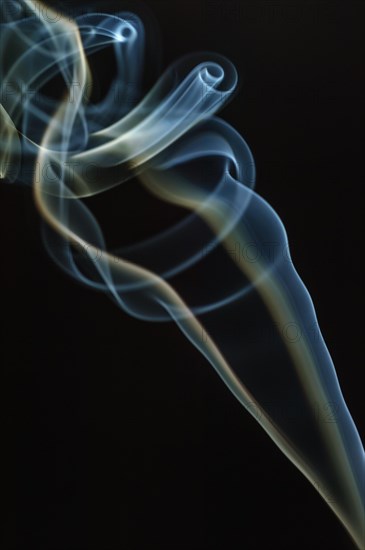 Trajectory of incense smoke in the air showing different shapes. France