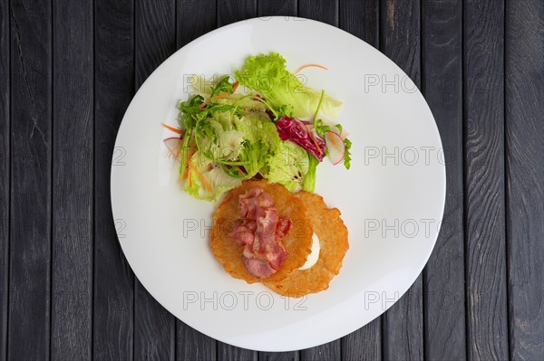 Traditional russian draniki with bacon and salad. Top view