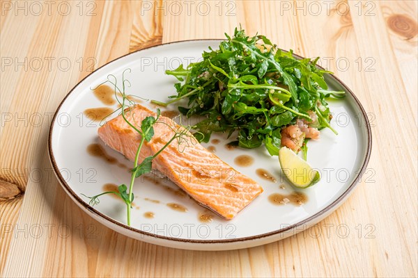 Steamed salmon with arugula and shrimps garnish