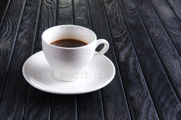 Cup of coffee on wooden table with space