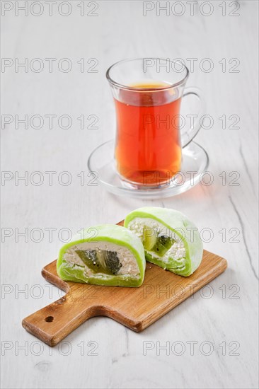 Sweet dessert mochi with kiwi cut on half with fruit tea