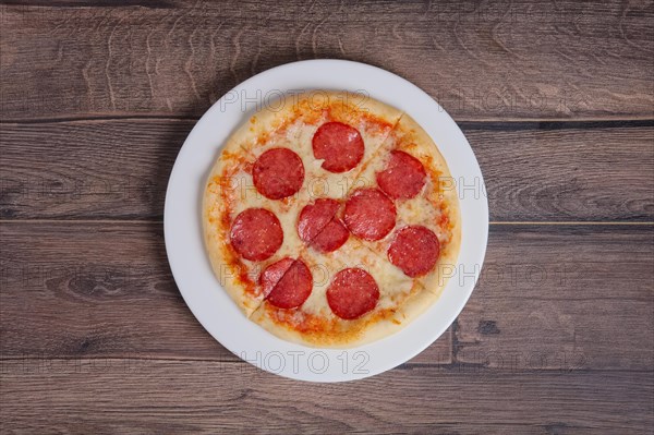 Top point of view of pizza pepperoni on wooden plate