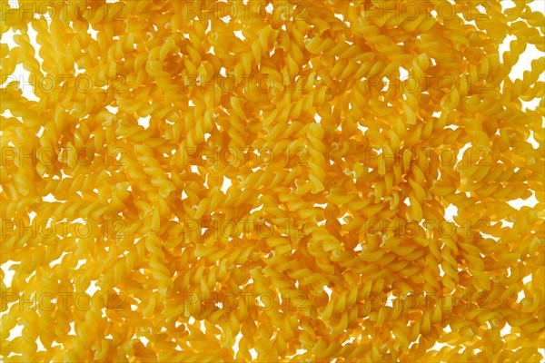 Top view of fusilli pasta scattered on white