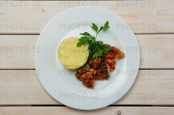 Portion of delicious fried meat in honey sauce with mashed potato. Top view