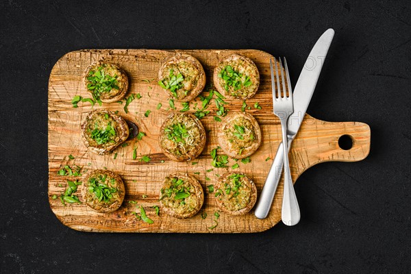 Top view of baked champignons stuffed with parsley