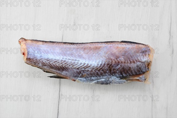 Frozen raw pollock carcass on wooden background