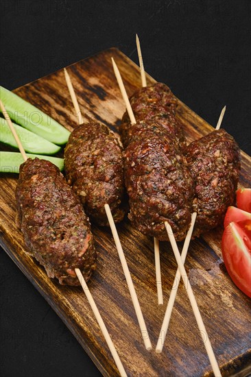 Lamb kebab on skewer on wooden board