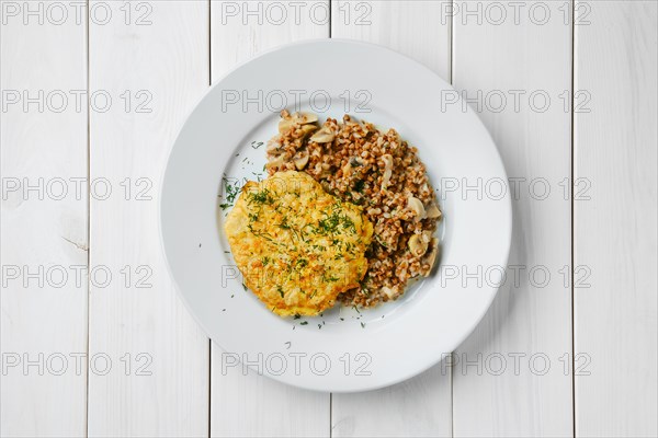 Top view of chicken cutlet in breading with buckwheat and mushrooms