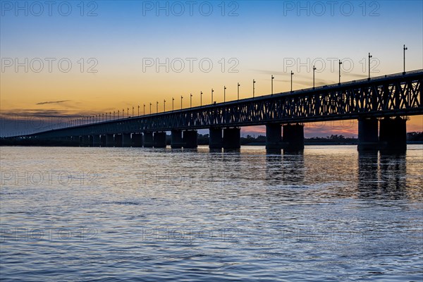 Giant bridge spanning over the Amur river at sunset
