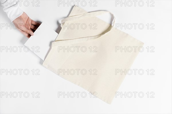 Person holding book from tote bag