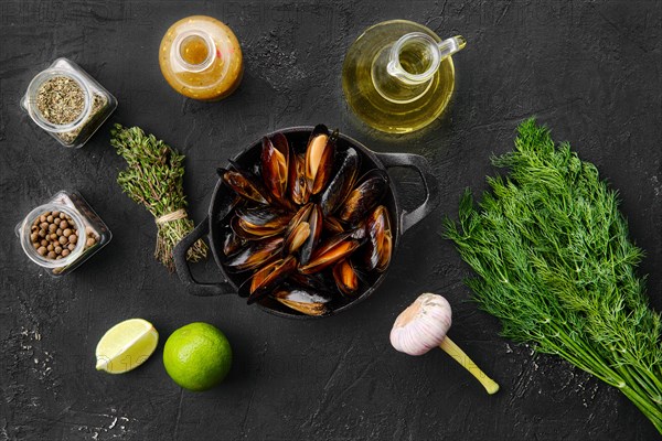 Top view of unpeeled mussels in frying pan spice and herbs