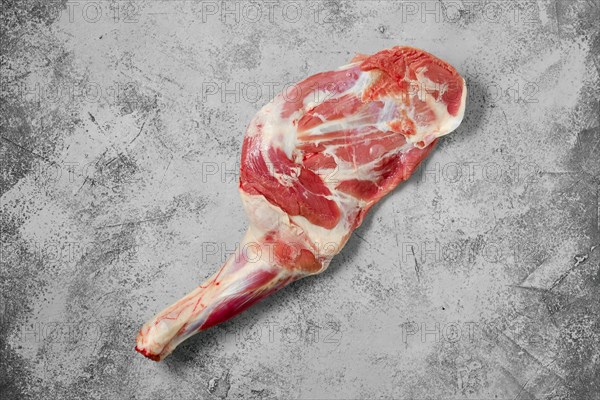 Raw lamb shoulder chump on on shabby grey background