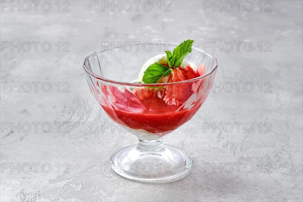 Ice cream with strawberry jam in a glass bowl