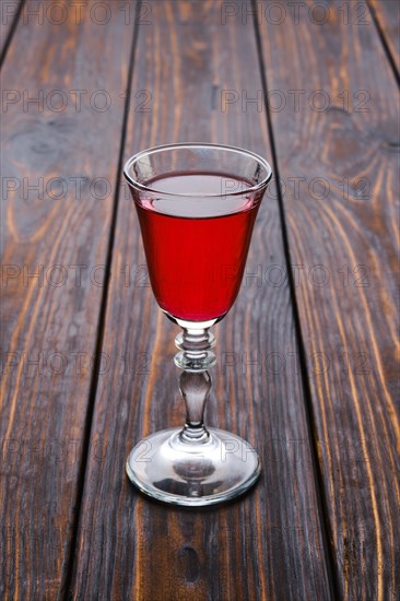 Vodka infused with berries on wooden background