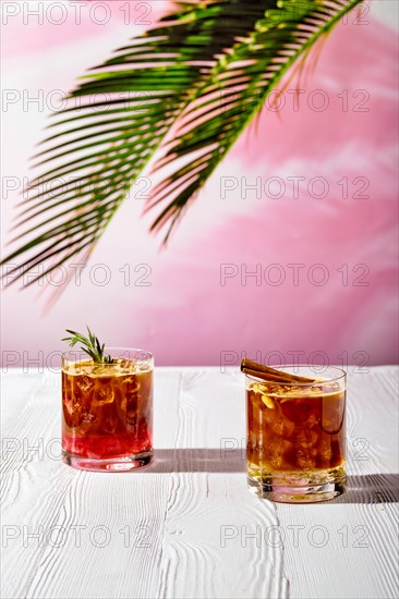 Refreshing espresso and tonic summer drinks on white table under hard sulight