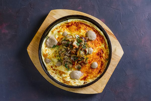 Vegetarian omelette with mushrooms in cast iron pan