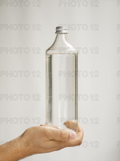 Close up hand holding water bottle mock up