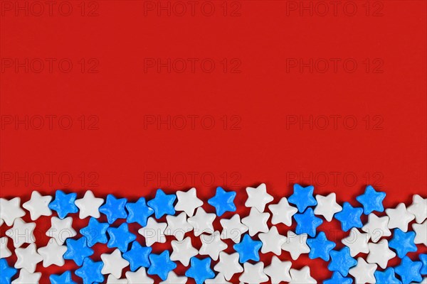 White and blue sugar sprinkle stars on red background