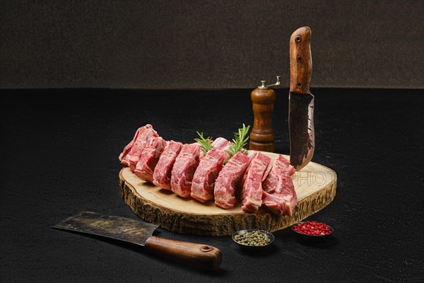 Raw fresh lamb rib roast on wooden slab