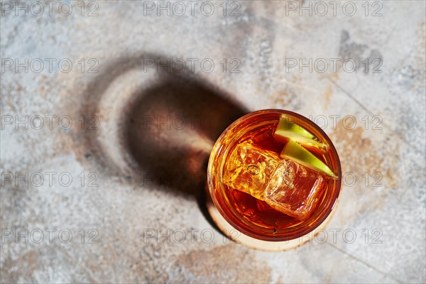 Top view of apple juice whiskey cocktail under hard sunlight