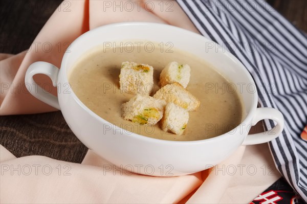 Creme soup with mushrooms in white bowl