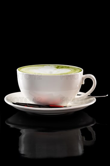 Cup of green tea latte isolated on black background