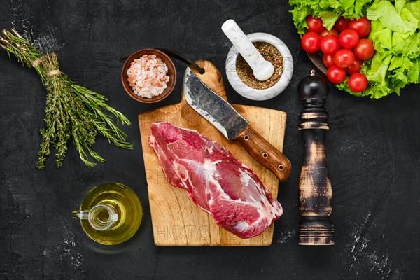 Overhead view of raw lamb rump on wooden cutting board