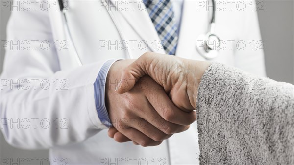 Close up male doctor patient shaking hands