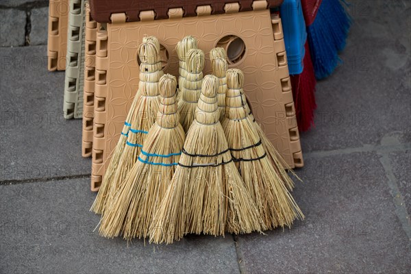 Set of yellow straw broom in a bazaar