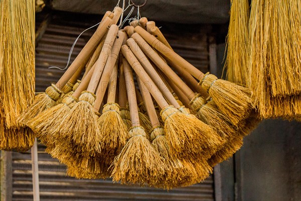 Set of yellow straw broom in a bazaar