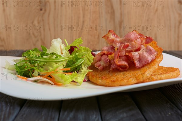 Traditional russian draniki with bacon and salad. Low angle view