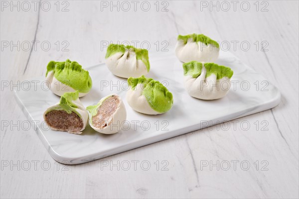 Frozen dumplings stuffed with pork meat and provencal herbs on marble serving plate