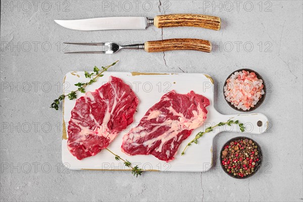 Overhead view of white table with raw fresh beef spider steak